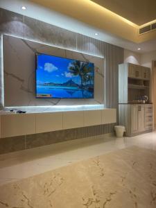 uma sala de estar com uma televisão de ecrã plano na parede em شقة فندقية ALzorah Ajman - الزوراء عجمان em Ajman