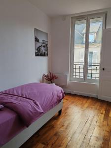 sypialnia z łóżkiem i dużym oknem w obiekcie Appartement T4 centre-ville w mieście Soissons