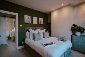 Un dormitorio con una cama grande y una pared verde en Modern Cottage Style House with Log Burner en Harrogate