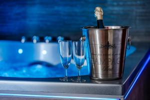 a bucket with a bottle of champagne and two wine glasses at Loft Romantique - Spa Privatif - Spa Noctambulles in Hyères