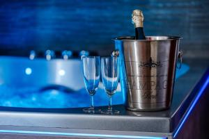 un secchio con una bottiglia di champagne e due bicchieri di vino di Loft Romantique - Spa Privatif - Spa Noctambulles a Hyères