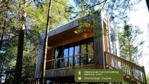a house with a deck in the woods at Cabin Zoobox 81 in Eastman
