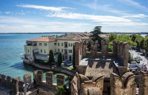 an aerial view of a building next to the water at Palladium Apt -Attico Vista Lago in centro Colombare, Sirmione in Sirmione