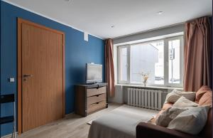 Cozy apartment near the sea في تالين: غرفة معيشة بها أريكة وتلفزيون