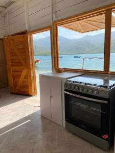 - une cuisine avec cuisinière et vue sur l'eau dans l'établissement Aqua Vista La Ciénaga, à Ocumare de la Costa