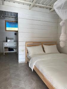 een slaapkamer met 2 bedden en een tafel met een tv bij Aqua Vista La Ciénaga in Ocumare de la Costa