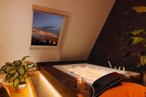 ein Bad mit einer Badewanne und einem Fenster in der Unterkunft Prestige Apartments 12 in Breslau