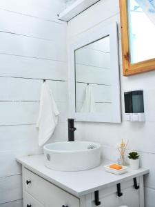 Baño blanco con lavabo y espejo en Aqua Vista La Ciénaga en Ocumare de la Costa
