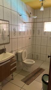 a bathroom with a toilet and a sink at Chácara jerivá in Boituva