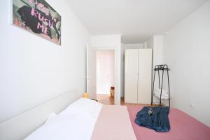 1 dormitorio con cama blanca y bolsa azul en Apartment Mia, en Zadar