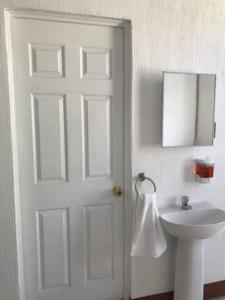 a bathroom with a white door and a sink at Casa Colibrí Apartamento 7A in Guatemala