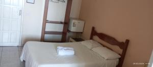 a bedroom with a bed with two towels on it at Pousada praia do riacho in Guarapari
