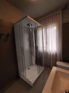 La salle de bains est pourvue d'une douche en verre et d'un lavabo. dans l'établissement House Cristina, à Vittorio Veneto