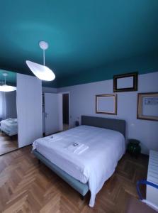 - une chambre avec un grand lit et un plafond bleu dans l'établissement House Cristina, à Vittorio Veneto