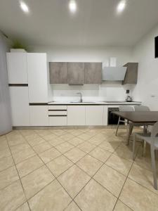 uma cozinha com armários brancos e uma mesa e cadeiras em Appartamento La Mola em Varazze