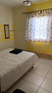 a bedroom with a bed and a window at Chácara jerivá in Boituva