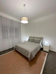 a white bedroom with a bed and a lamp at Appartamento La Mola in Varazze