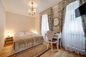 a bedroom with a bed and a desk and a television at Leśna Polana- blisko centrum, Mini Spa, cicha, spokojna okolica, parking gratis in Krynica Zdrój