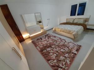 een slaapkamer met een bed en een tapijt op de vloer bij Luxury Sea-view 2 bedrooms apartment in Hadaba in Sharm El Sheikh