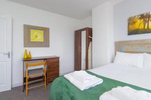 1 dormitorio con 1 cama y escritorio con silla en Spacious 4 Bed house W/Free Parking Sleeps 7 Near Walsgrave Hospital en Wyken