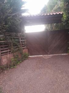 a brown garage with a fence and a roof at Chácara jerivá in Boituva