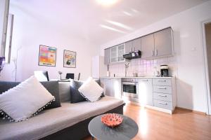 a living room with a couch and a kitchen at Apartment Mia in Zadar