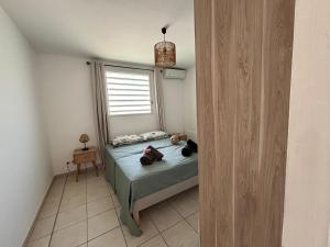 una camera da letto con un letto con due borse sopra di Ti Diamant Bo Kaï a Le Diamant