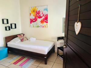 a bedroom with a bed and a painting on the wall at Casa de Lis Hotel & Tourist Info Centre in Turrialba