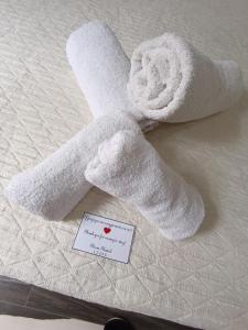 a towel on top of a bed with a note at Room Rental in Naples