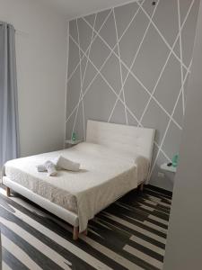 a bedroom with a white bed with a striped carpet at Room Rental in Naples