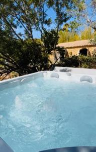 una gran piscina en un patio con árboles en La grange des amoureux piscine jacuzzi et massages, en Le Beausset
