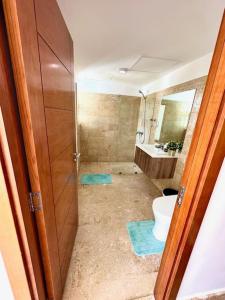 ein Bad mit einem WC und einem Waschbecken in der Unterkunft Gourgeous 2 bedroom Beach Apt Playa Nueva Romana in San Pedro de Macorís