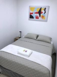 un letto in una camera da letto con una foto sul muro di Casa Colibrí Apartamento 7C a Guatemala