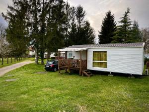 ein kleines weißes, winziges Haus mit einer Veranda in der Unterkunft *Air-conditioned* Mobilhome near Europapark in Boofzheim