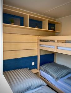 two bunk beds in a small room with at *Air-conditioned* Mobilhome near Europapark in Boofzheim