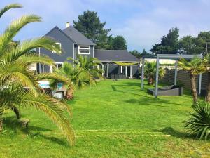 een huis met palmbomen in de tuin bij Villa de 5 chambres a Bretteville sur Ay a 400 m de la plage avec piscine privee jardin clos et wifi in Bretteville-sur-Ay