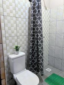 a bathroom with a toilet and a shower at Lovely Double Bed with a Private Garden Nook in Kira