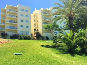 アルヴォルにある2 bedrooms apartement with city view shared pool and furnished garden at Alvor 1 km away from the beachのヤシの木が目の前に広いアパートメントです。