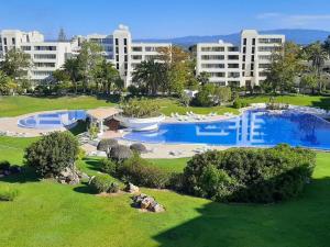 アルヴォルにある2 bedrooms apartement with city view shared pool and furnished garden at Alvor 1 km away from the beachのリゾートで、大きなスイミングプールと建物を併設しています。