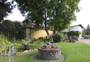 a garden with a fountain in the middle of a yard at Ferienwohnung Wunderlich in Krausnick