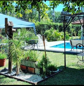 un jardin avec une piscine, une table et un banc dans l'établissement Casa Quinta con pileta Tortuguitas Bs As, à Manuel Alberti