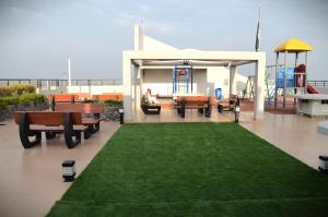 een patio met een tuinhuisje en een groen gazon bij LandmarkIII Apartment in Islamabad