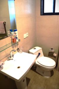 een badkamer met een wit toilet en een wastafel bij LandmarkIII Apartment in Islamabad