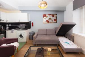 ein Wohnzimmer mit einem Sofa und einem Tisch in der Unterkunft Warm&Welcoming City Centre Apartments by Meadows 6 in Edinburgh
