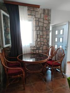 a table and chairs in a room with a stone wall at Fortress Sofranac in Cetinje