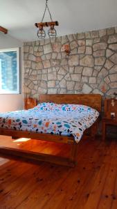 a bed in a room with a stone wall at Fortress Sofranac in Cetinje
