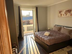 a bedroom with a bed and a large window at Casa vacanza Nada in Dogliani