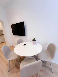 einen weißen Tisch und Stühle in einem Zimmer mit einem TV in der Unterkunft Apartman No. 2 in Zagreb