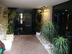 eine Lobby mit Topfpflanzen in einem Gebäude in der Unterkunft Calandre Hotel in São Paulo