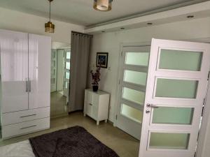 - une chambre avec une porte blanche et une armoire blanche dans l'établissement Mirror Apartment, à Novi Pazar